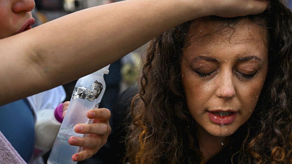 A protester cleaning tear gas from the eyes